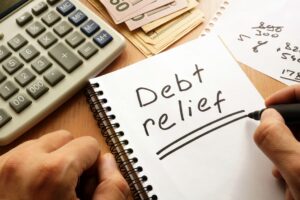 Debt relief written on a notepad along with a calculator and money